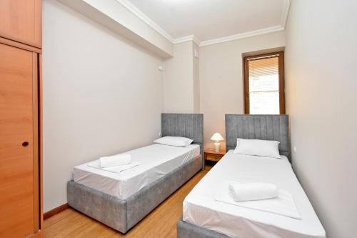 two beds in a small room with white walls at Prime Apartment 2 Bedroom In The Center Of Yerevan,Near Republic Square in Yerevan