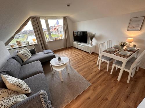 uma sala de estar com um sofá e uma mesa em Ferienwohnung Deichblick em Emden