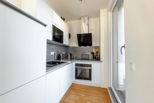 a kitchen with white cabinets and a stove at Penthouse I Dachterrasse I Tiefgaragenstellplatz I nahe Bhf, JoHo, Brita-Arena in Wiesbaden