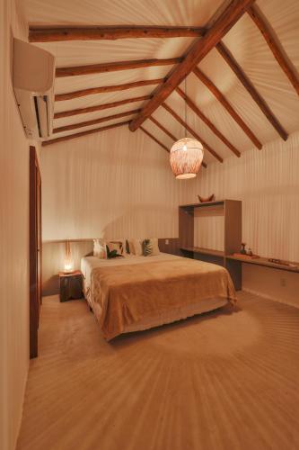 a bedroom with a bed and a chandelier at Pousada Tatuá in Pôrto de Pedras