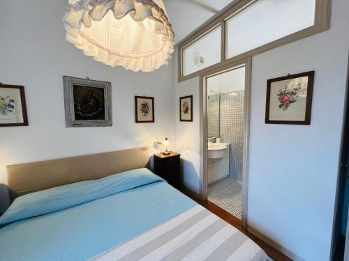 een slaapkamer met een bed en een kroonluchter bij Appartamenti sul mare Villa il Fortullino in Case Fortullino