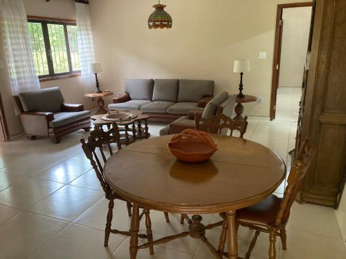 een woonkamer met een tafel en stoelen en een bank bij Aconchegante casa nas montanhas de Serra Negra in Serra Negra