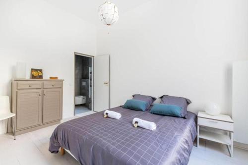 una camera da letto con un letto e due asciugamani di Magnifique Appartement avec climatisation en Hyper Centre de Bordeaux a Bordeaux