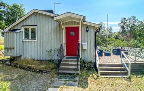 una pequeña casa con una puerta roja y escaleras en Amazing Home In Vaxholm With Kitchen en Vaxholm