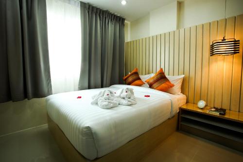 a bedroom with a bed with stuffed animals on it at Patt Serviced Apartments in Chon Buri