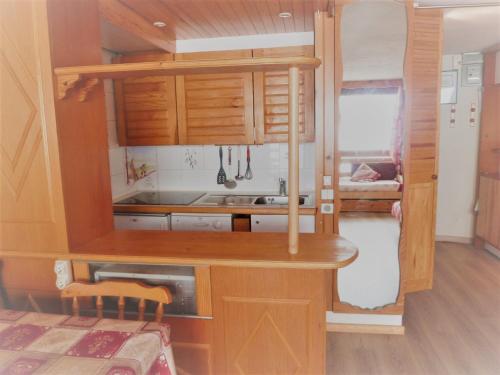 a small kitchen with wooden cabinets and a sink at Studio Tignes, 1 pièce, 5 personnes - FR-1-411-387 in Tignes