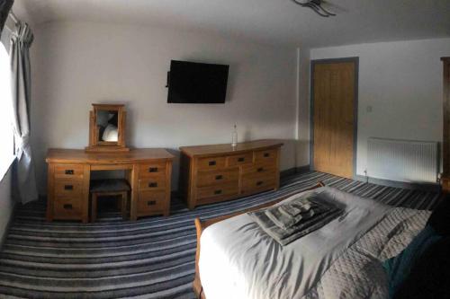 a bedroom with a bed and a dresser and a television at 2 Bedroom apartment, Cononley near Skipton in Cononley
