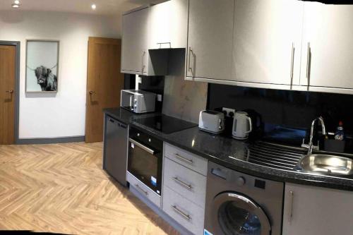 a kitchen with a stove and a sink and a dishwasher at 2 Bedroom apartment, Cononley near Skipton in Cononley