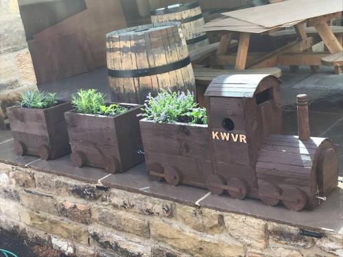 a wooden train on a wall with some plants at 2 Bedroom apartment, Cononley near Skipton in Cononley