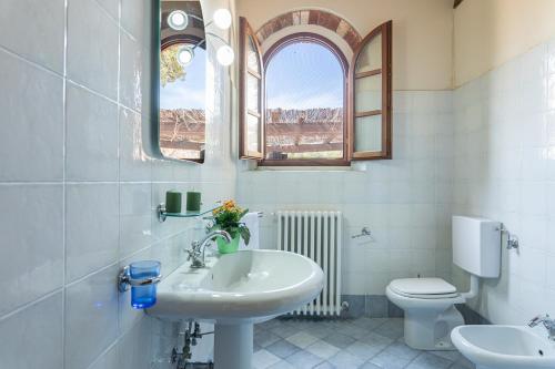 y baño con lavabo, aseo y espejo. en Casale Presciano, en Pergine Valdarno