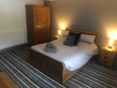 1 dormitorio con 1 cama grande, 2 mesitas de noche y 2 lámparas en 2 Bedroom apartment, Cononley near Skipton, en Cononley