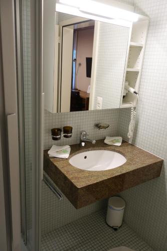 a bathroom with a sink and a mirror at Hotel Bären in Rothenburg