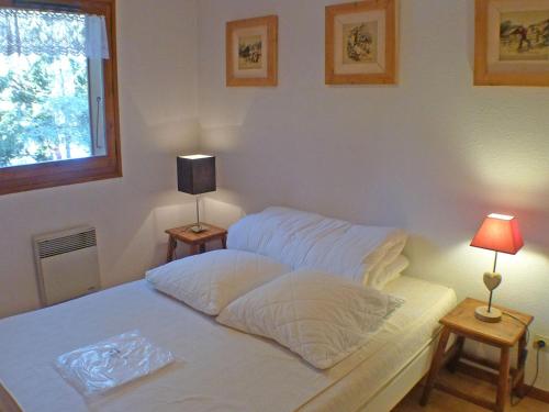 une chambre avec deux lits avec des draps blancs et une fenêtre dans l'établissement Charmant appartement 2 pièces mezzanine avec balcon, parking et casier à skis - FR-1-629-38, à Samoëns