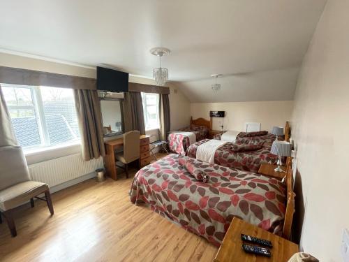 a hotel room with two beds and a desk at GoldenDawn Guest House in Citywest