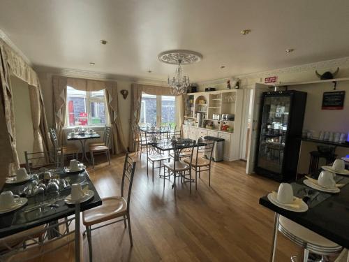 a dining room with tables and chairs and a kitchen at GoldenDawn Guest House in Citywest