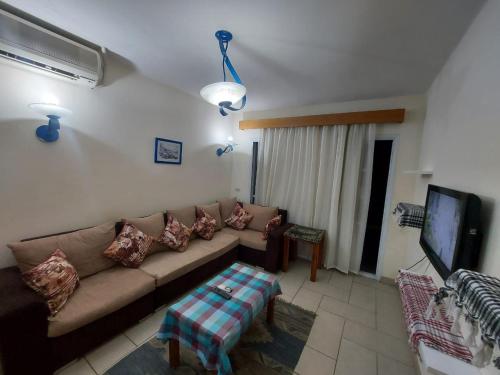 sala de estar con sofá y TV en Happy day, en Sharm El Sheikh