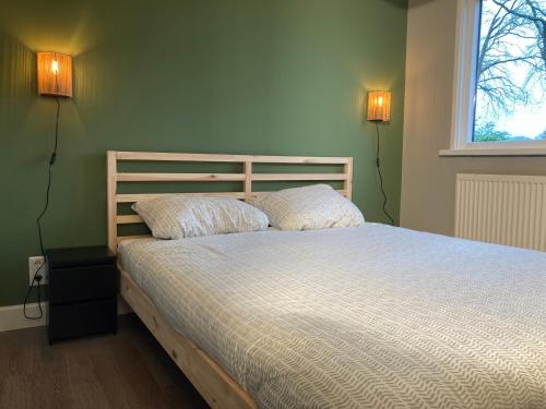 een slaapkamer met een bed met 2 kussens erop bij Natuurhuisje Bergvliet - Nature, Golf & Wellness in Oosterhout