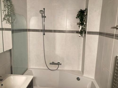 een badkamer met een douche en een wit bad bij Natuurhuisje Bergvliet - Nature, Golf & Wellness in Oosterhout