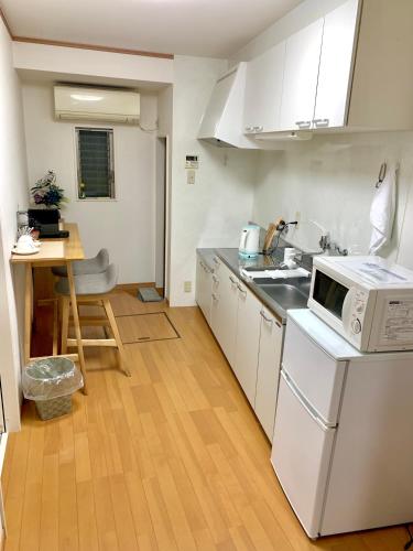 a small kitchen with a sink and a microwave at 花楓舎-Sakura & Maple Guest House-ゲストハウス in Kyoto