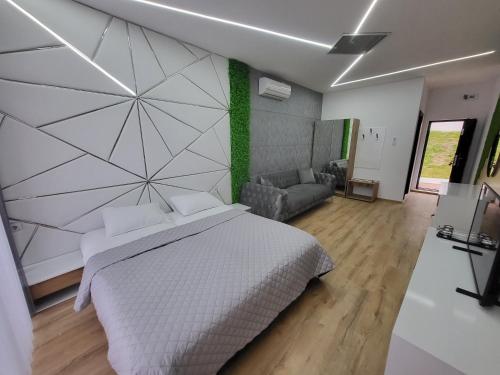 a bedroom with a large white bed and a couch at Вилно селище PARADISE VIEW in Sarnitsa