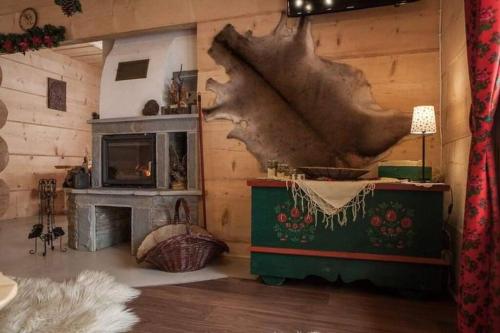 a living room with a fireplace and a log wall at Góralskie przytulne Domki u Kantora in Poronin