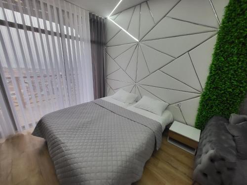 a bedroom with a large bed and a wall with plants at Вилно селище PARADISE VIEW in Sarnitsa