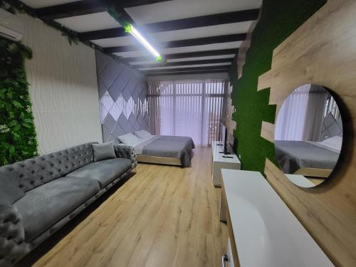 a room with two beds and a couch and a mirror at Вилно селище PARADISE VIEW in Sarnitsa