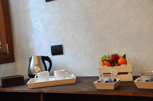 a counter with cups and a bowl of fruit on it at NAZIONALE Camere in Montebelluna