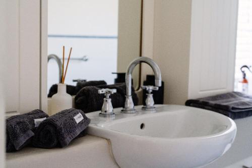 Cottesloe Beach View Apartments #11 في بيرث: حمام مع حوض ومرآة