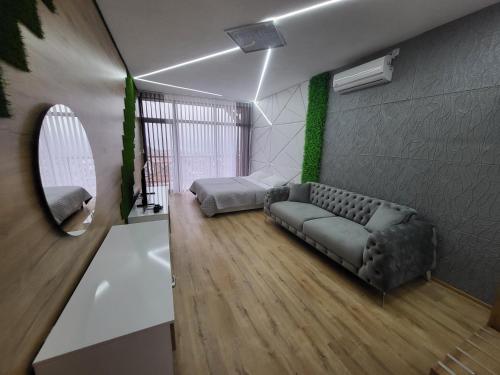 a living room with a couch and a bed at Вилно селище PARADISE VIEW in Sarnitsa