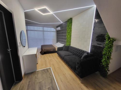 a living room with a black couch in a room at Вилно селище PARADISE VIEW in Sarnitsa