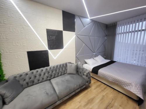 a bedroom with a bed and a couch in it at Вилно селище PARADISE VIEW in Sarnitsa
