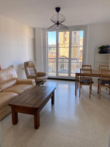 un salon avec un canapé et une table dans l'établissement Appartement deux chambres centre historique avec ascenseur et garage, à Manosque