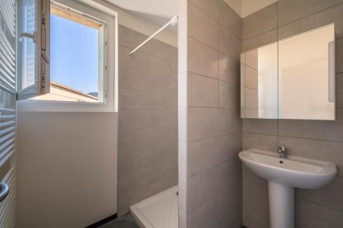 une salle de bain avec un lavabo et des toilettes et une fenêtre dans l'établissement Appartement deux chambres centre historique avec ascenseur et garage, à Manosque