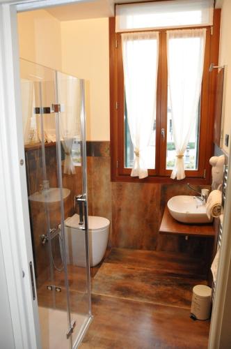 La salle de bains est pourvue d'une douche en verre et d'un lavabo. dans l'établissement NAZIONALE Camere, à Montebelluna