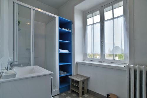 La salle de bains est pourvue d'un lavabo, d'une douche et d'une fenêtre. dans l'établissement Ile Celée - Maison de caractère proche plage, à Dinard