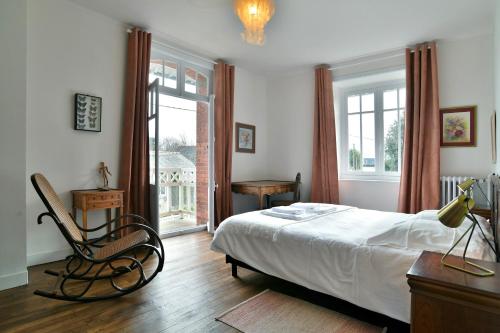 een slaapkamer met een bed, een stoel en een raam bij Ile Celée - Maison de caractère proche plage in Dinard