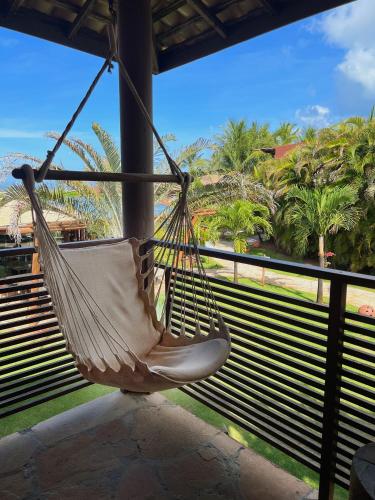 a hammock hanging from a porch with a view of the ocean at Aruanã Eco Praia Hotel in Aracaju