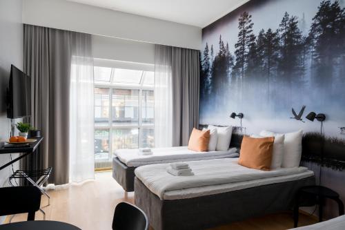 a hotel room with two beds and a large window at Hiisi Hotel Lohja in Lohja