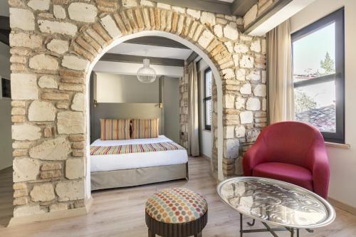 - une chambre avec un lit et une chaise rouge dans l'établissement Cozy Studio Flat near Hadrians Gate, à Antalya