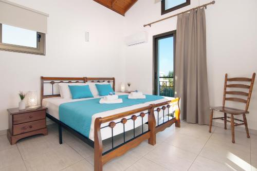1 dormitorio con 1 cama con silla y ventana en Villa Ingrid, en Ayia Napa