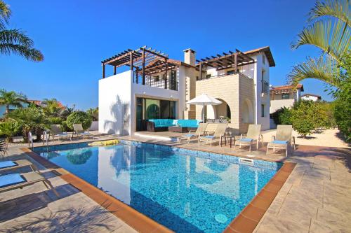a villa with a swimming pool in front of a house at Villa Ingrid in Ayia Napa
