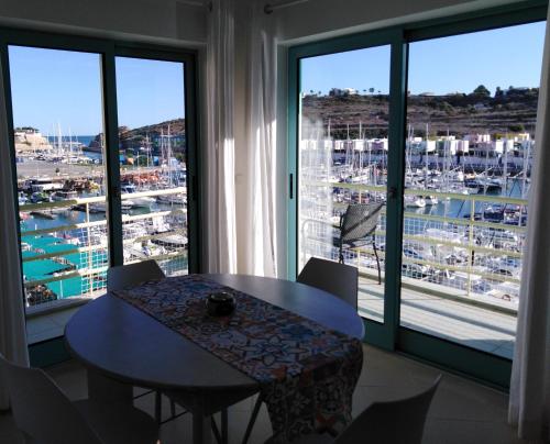 アルブフェイラにあるApartemento da Marinaの大きな窓のある客室で、テーブルと椅子が備わります。