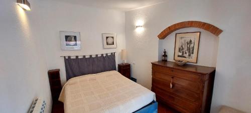 フィナーレ・リーグレにあるCasa Buraggiのベッドルーム1室(ベッド1台、木製ドレッサー付)