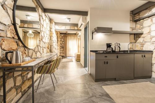 a kitchen with a counter and a stone wall at Charming Flat near Hadrians Gate in Antalya