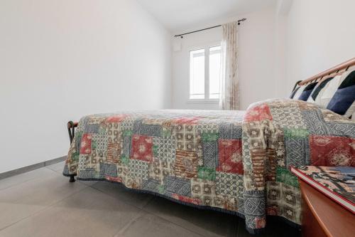 a bed with a quilt on it in a room at Realkasa Fiera District Flat in Bologna