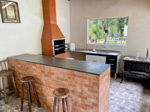 a kitchen with a brick bar and a brick oven at Chácara das Suculentas in Mairiporã