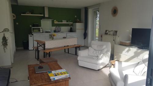 ein Wohnzimmer mit einem Sofa und einem Tisch in der Unterkunft Gîte cocooning avec piscine in Bougé-Chambalud