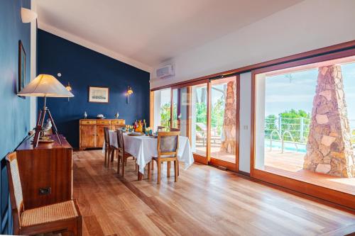 a dining room with a table and a large window at Tenuta Delle Ripalte in Capoliveri