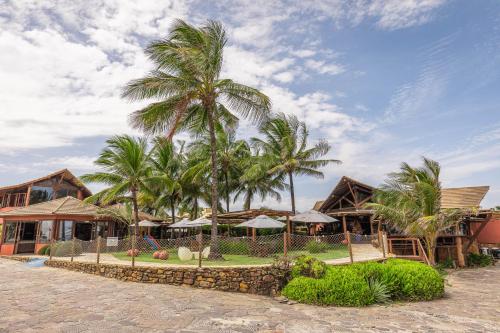 a resort with palm trees in front of a building at Aruanã Eco Praia Hotel in Aracaju